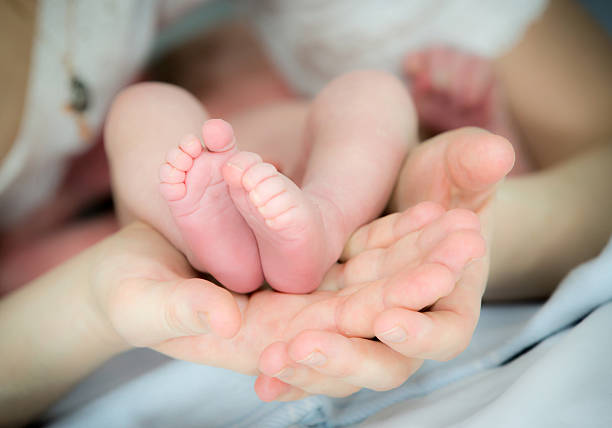 istock baby feets in mother hands 592670640