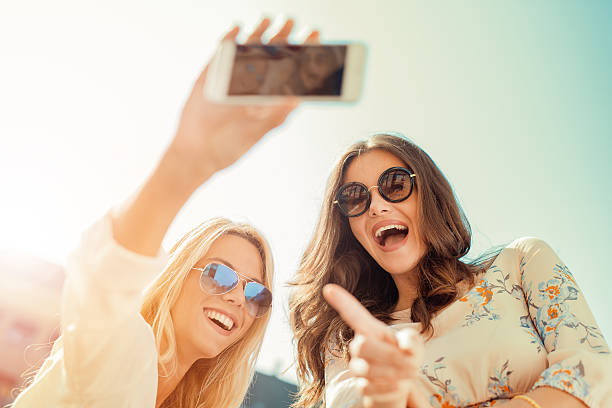 istock Beautiful smiling girls making selfie 592671924