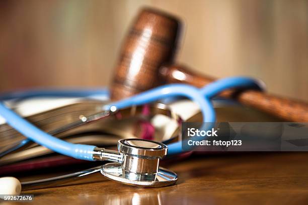 Martillo Y Estetoscopio Del Juez En La Mesa De La Sala De Audiencias Foto de stock y más banco de imágenes de Asistencia sanitaria y medicina