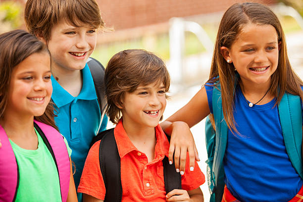 istock Elementary-age children, friends on school campus going back to school. 592675138