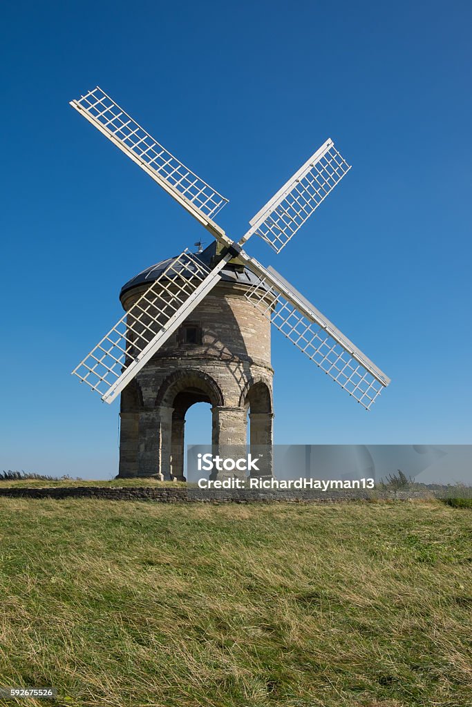 Chesterton Windmill, Warwickshire The restored Chesterton Windmill, a tall round stone building with sails painted white, a prominent landmark in Warwickshire, central England Building Exterior Stock Photo