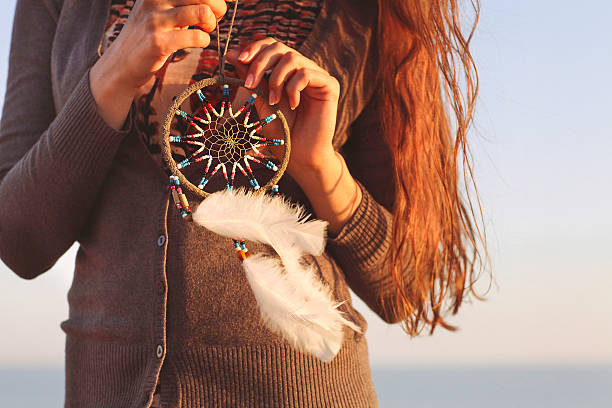 mujer morena con el pelo largo sosteniendo atrapasueños - tribal music fotografías e imágenes de stock