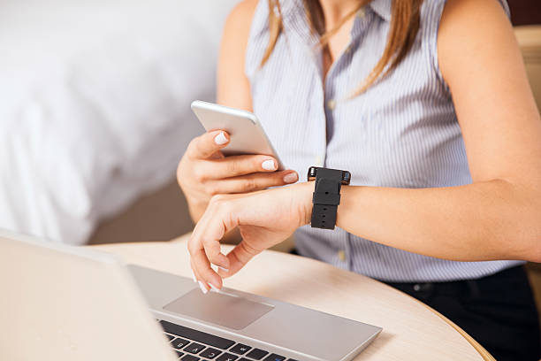 istock Woman syncing smart watch to smartphone 592680846