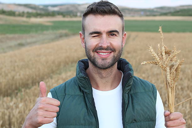 istock Man standing in field giving thumbs up 592685990