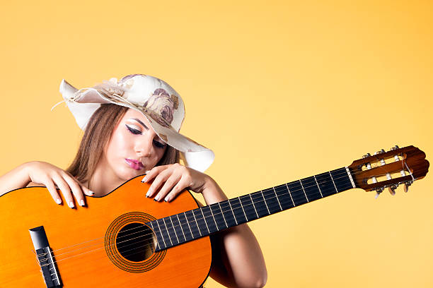 LGBTQ+ young woman playing guitar, with alternative hairstyle as self-expression giving confidence to be accepted