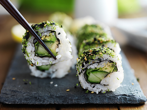 Set of various kinds and types of Japanese food sushi fish ready to eat on a wooden tray on a white background.