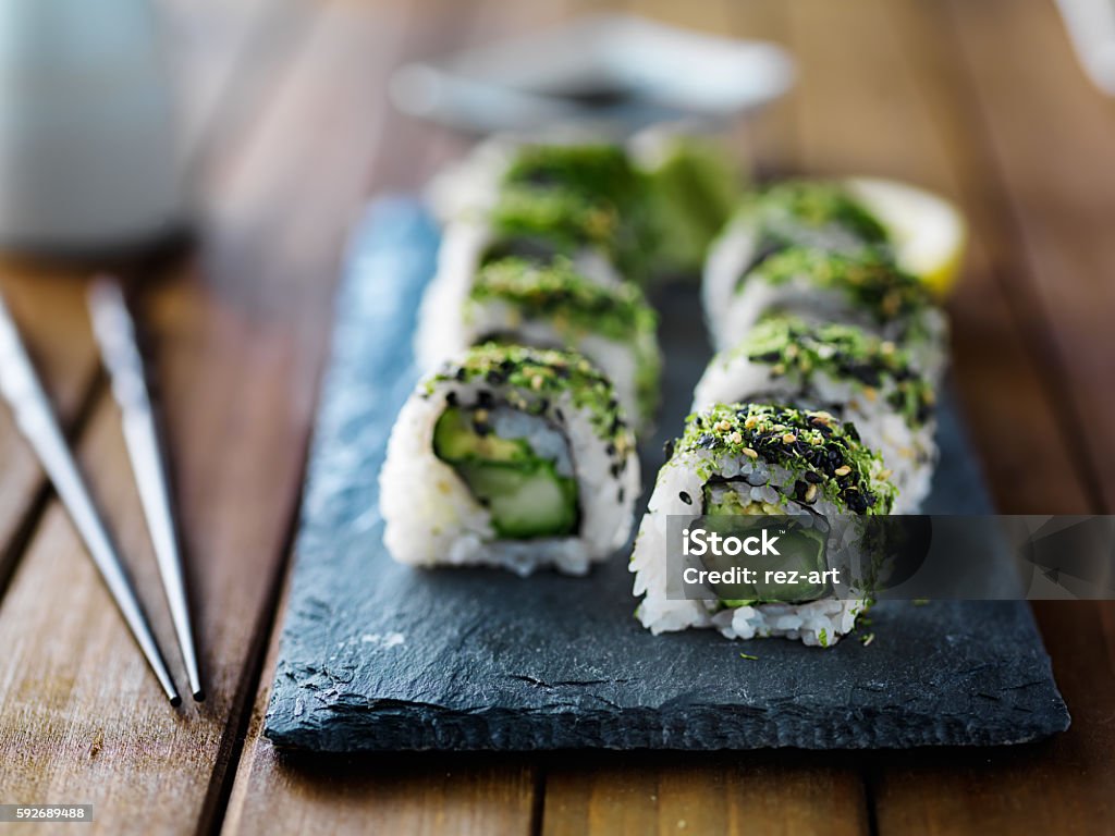 Green kale sushi roll healthy kale, avocado and cucumber sushi roll on slate serving tray Avocado Stock Photo