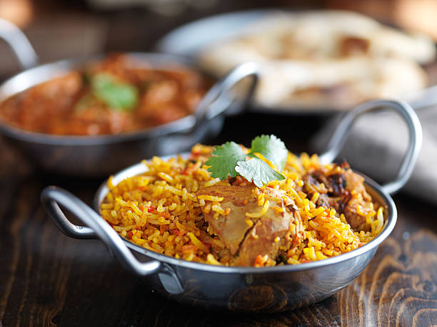balti dish with indian chicken biryani balti dish with indian chicken biryani and curry in the background indian food stock pictures, royalty-free photos & images