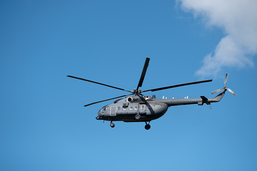 Solana Beach, California, USA- April 17, 2024: US Navy helicopter flying in a bright blue sky