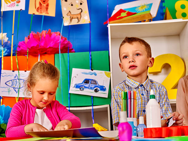 istock Group kids mold from plasticine in kindergarten . 593298590