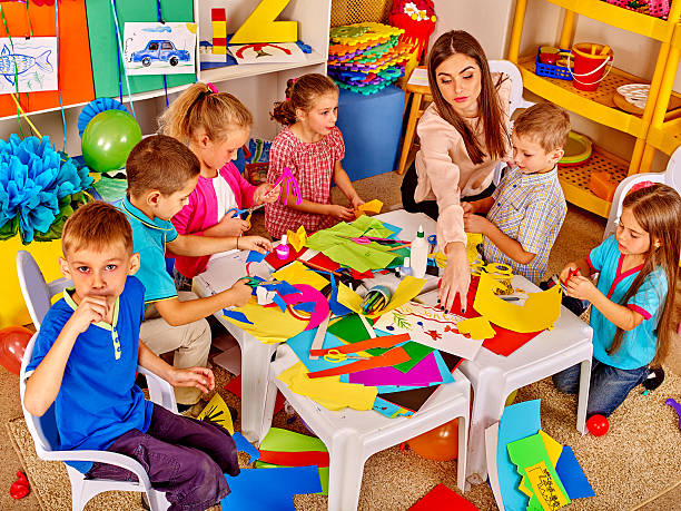 istock Children with teacher are making something out of colored paper. 593298708