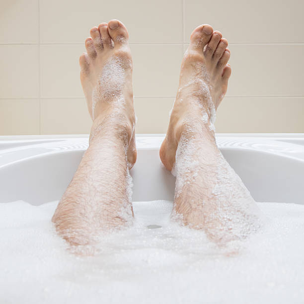 istock Men's feet in a bathtub, selective focus on toes 593301110