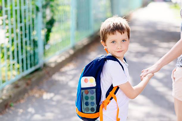 istock 7 years old boy going to school with his mother 593302182