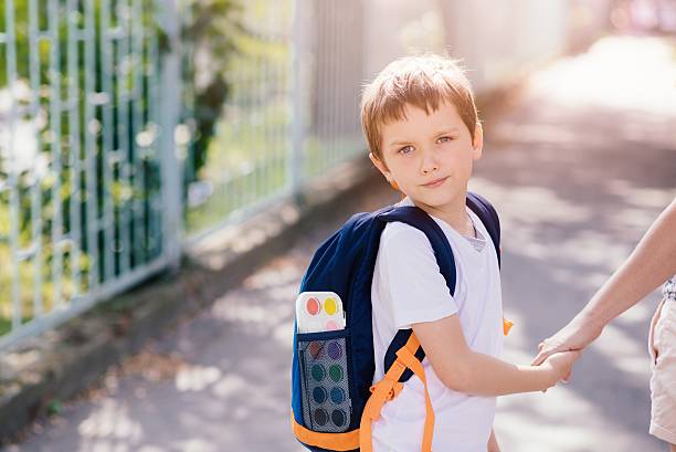 istock 7 years old boy going to school with his mother 593302238