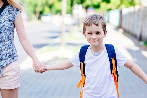 istock 7 years old boy going to school with his mother 593302370