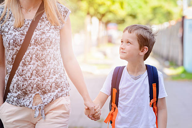 istock 7 years old boy going to school with his mother 593302542