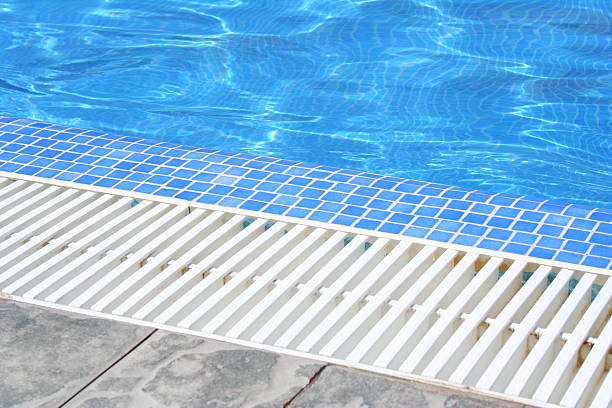 istock Swimming pool white grating grille with clear blue water and 593303060