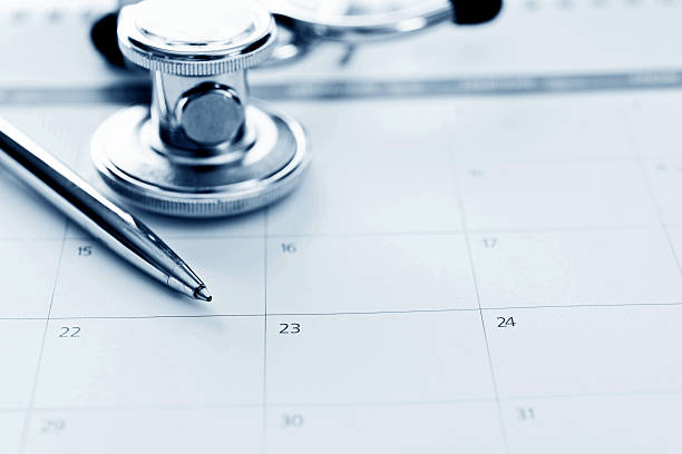 カレンダーの聴診器とペン - healthcare and medicine calendar medical exam plan ストックフォトと画像