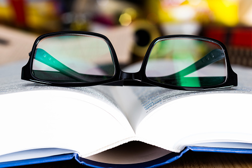 Close up glasses and open book on the table