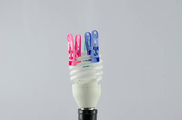 istock Energy saving lamp  The clothespin isolated on a  White backgrou 593303810