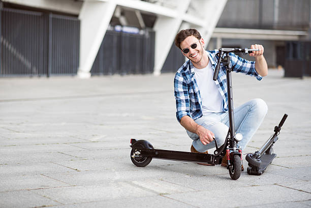 istock Positive man holding kick scooter 593306506