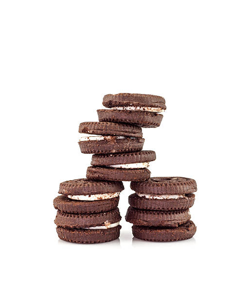 istock Chocolate cookies with cream filling tower isolated on white background. 593307042