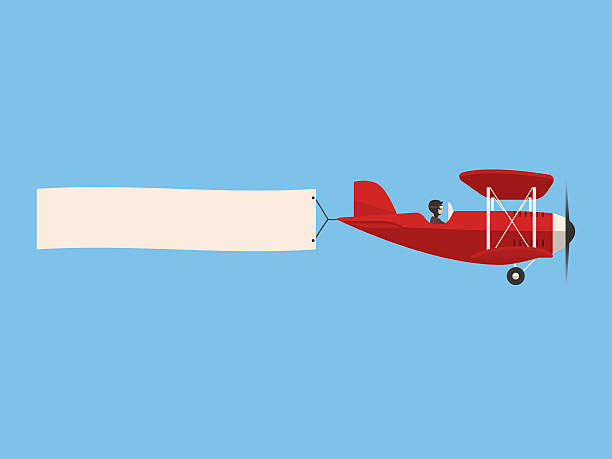 retro-flugzeug am himmel mit poster, flaches design - flugzeug stock-grafiken, -clipart, -cartoons und -symbole