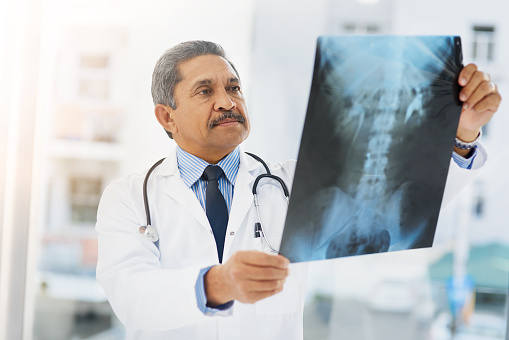Shot of a mature doctor looking at an x ray