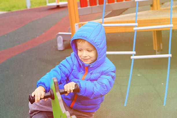 istock child having fun at playground riding on the spring horse 593311560
