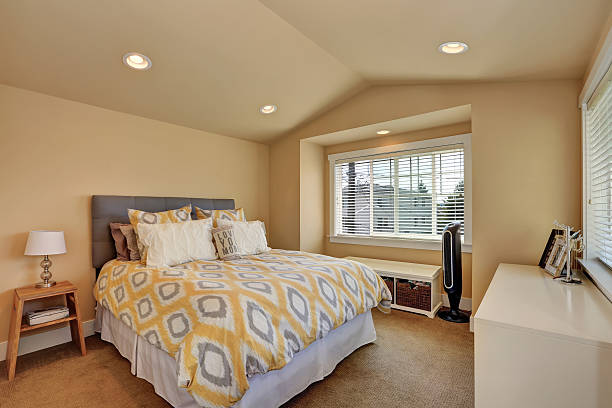 istock Vaulted ceiling bedroom interior in beige colors 593313362