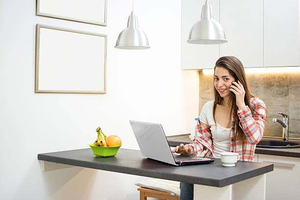 istock Young woman working on computer and talking on phone. 593314592