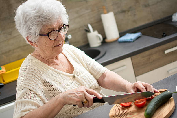 istock Senior woman cutting vegetables in the kitchen. 593315418