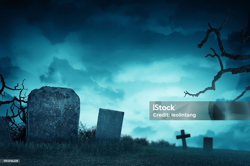 Creepy atmosphere in the cemetery with tombstone Creepy atmosphere in the cemetery with tombstone in the night, fog and trees that live twigs Cemetery Stock Photo