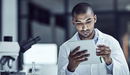 Shot of a scientist recording his findings on a digital tablet