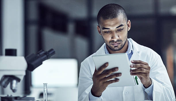 The use of electrical medical records increases Shot of a scientist recording his findings on a digital tablet medical education stock pictures, royalty-free photos & images