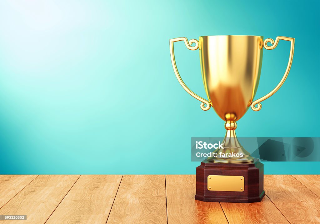 Golden trophy cup on table Golden trophy cup on wood table over blue wall. 3D illustration of sports award goblet Trophy - Award Stock Photo