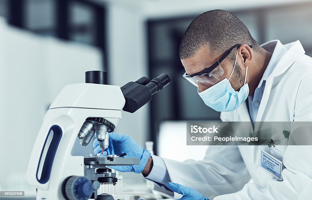 He’s eager to unlock medical mysteries Cropped shot of a young male scientist working in his lab Microscope Stock Photo