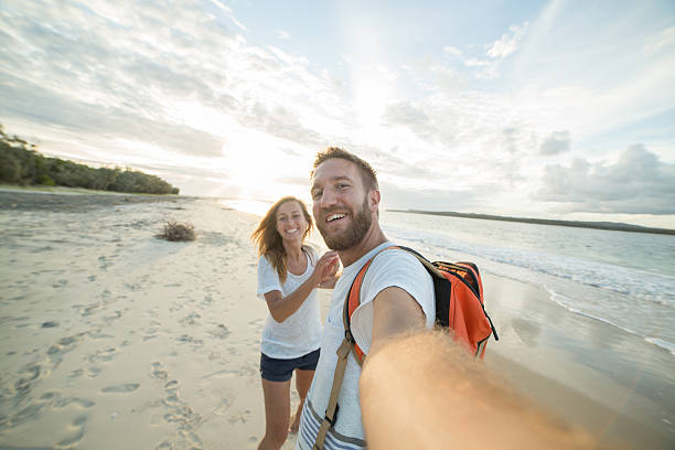 일몰에 해변에서 장난 젊은 부부의 자화상 - australia photographing camera beach 뉴스 사진 이미지