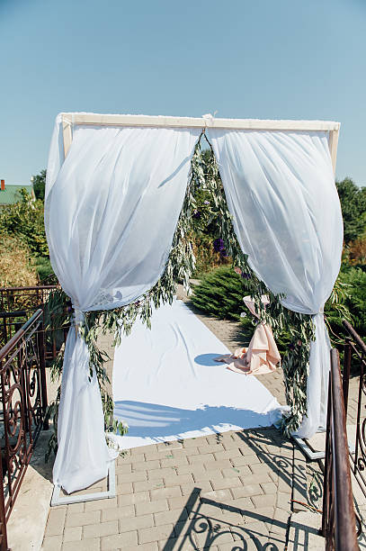 istock white wedding arch decorated with flower outdoors 593325064