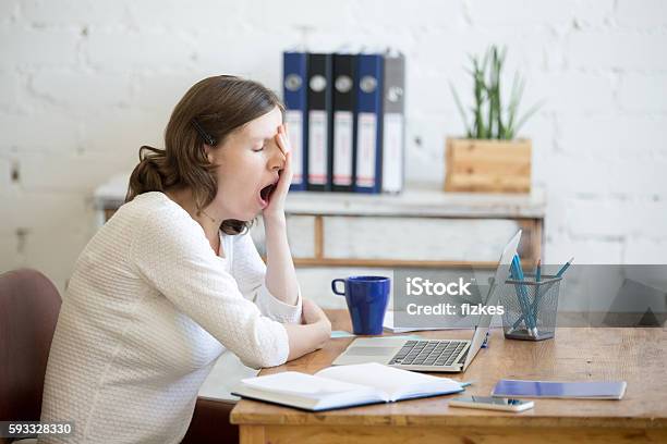 Mujer Trabajadora Joven Adormiada Bostezando Foto de stock y más banco de imágenes de Cansado - Cansado, Bostezar, Mujeres