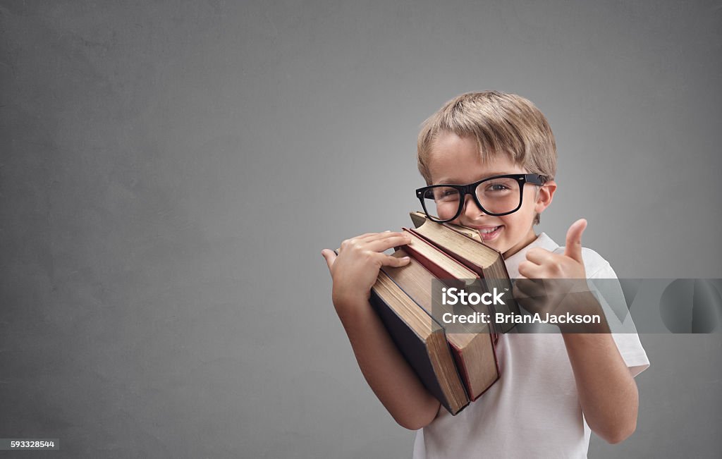 Boy going back to school Happy smiling boy with books going back to school putting his thumb up First Day Of School Stock Photo