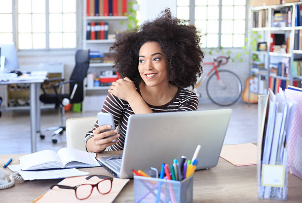 istock Smiling young woman sitting at workplace 593331984