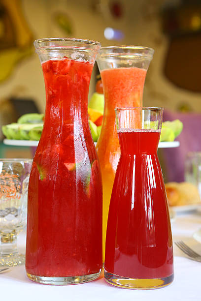 transparent glass jars with fruit drink on table