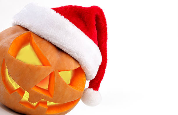 Halloween pumpkin shiny inside wearing christmas hat on white stock photo
