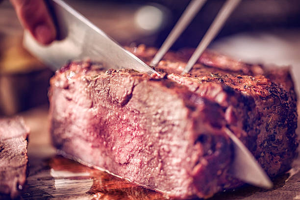 istock Cutting Roast Beef with Potatoes and Root Vegetables 593333920