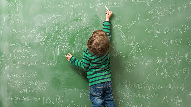 istock Little boy writing on green blackboard 593334118