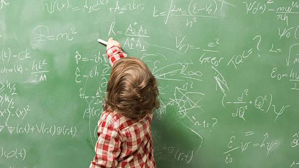 istock Little boy writing on green blackboard 593334124