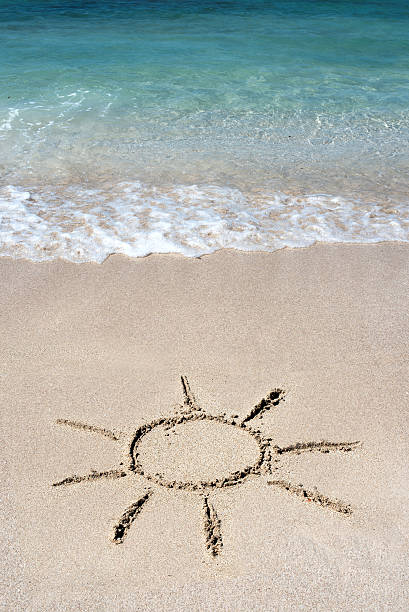 istock Hand drawn shining sun on beach sand 593335912