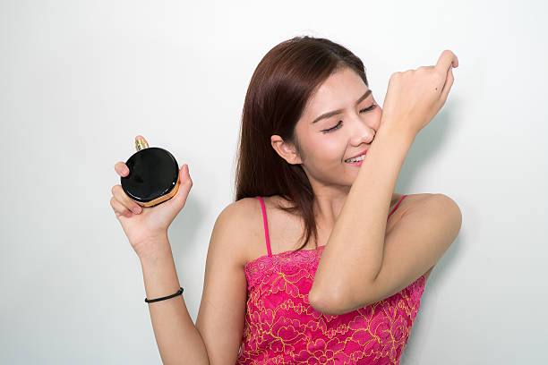 istock beautiful woman applying perfume on her body 593337504