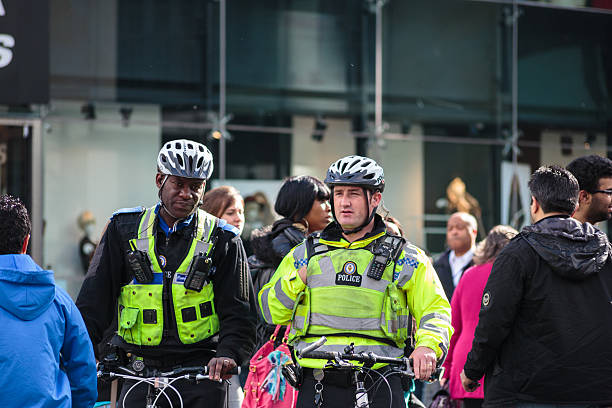 Community officer with police officer patrolling on bicycles stock photo